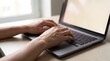 © Rendara Studio - Skilled hands typing on a laptop keyboard beside a window, focused remote work closeup