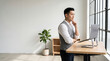 © Rendara Studio - Problem solving developer standing at an ergonomic desk with hand on chin, deep in thought