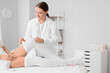 © Pixel-Shot - Compression therapy and venous health, doctor helping patient put on medical stockings for circulation support and edema treatment in clinic office