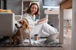 © Pixel-Shot - Remote work lifestyle with pet, woman working from home on laptop with beagle dog in cozy living room environment for freelance and digital nomad life