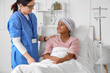 © Pixel-Shot - Cancer treatment and patient care, nurse supporting young girl with headscarf in hospital bed with intravenous drip for chemotherapy and recovery
