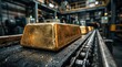 © CaptureCollabStudios - Close up of heavy gold bars moving on an industrial chain conveyor belt inside a mint factory