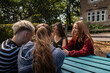 © Pedro Merino/Stocksy - Friends catch up over a phone in a shaded courtyard