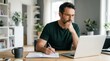 © Panpatsa - Man studying or working from home with a laptop, notebook, and coffee mug.