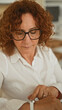 © Krakenimages.com - Woman points finger to watch on wrist in building office as she checks time for work schedule; concentration punctuality.