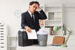 © Pixel-Shot - Burnout and workplace stress, tired businessman holding document near paper shredder in office with deadline pressure and corporate anxiety concept