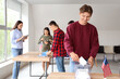 © Pixel-Shot - Voter turnout and democracy, young man casting ballot in election with diverse people at polling station in united states with american flags