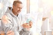 © Pixel-Shot - Respiratory health and chronic disease management, mature man using a nebulizer mask for asthma or copd treatment at home with positive recovery outlook