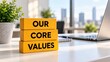 © Aleksandr - Our Core Values Written on Yellow Wooden Blocks on Modern Office Desk with Laptop and City View