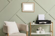 © Pixel-Shot - Home office setup, remote work and productivity with printer, blank picture frame and comfortable armchair in a modern minimalist interior