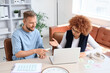 © Pixel-Shot - Workplace collaboration and professional feedback, diverse colleagues discussing project progress on a laptop in a modern office environment