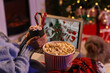 © Pixel-Shot - Christmas movie night and holiday relaxation, person watching festive film on laptop with hot cocoa and popcorn at home during winter season