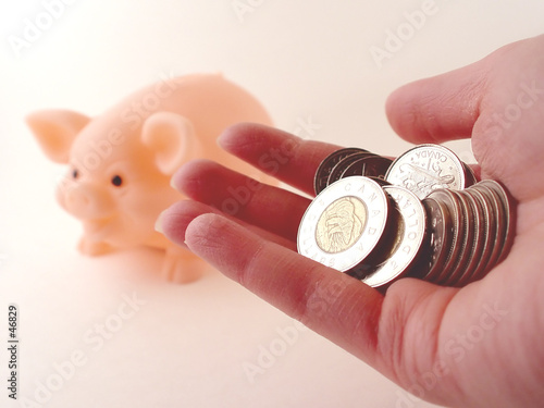 holding money and a piggy bank