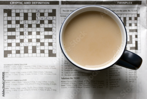 a cup of tea on a newspaper showing the crossword