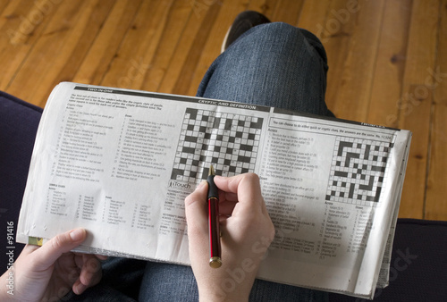 a relaxed person casually completing the crossword
