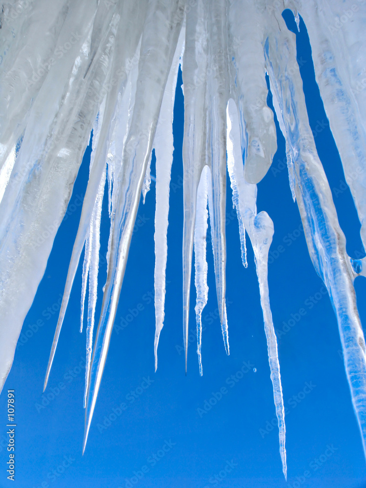 big icicles on blue sky background - obrazy, fototapety, plakaty 