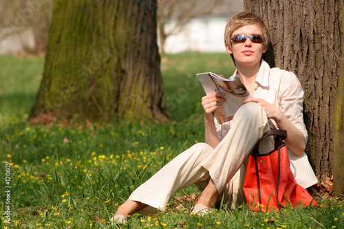 woman with magazine in the park