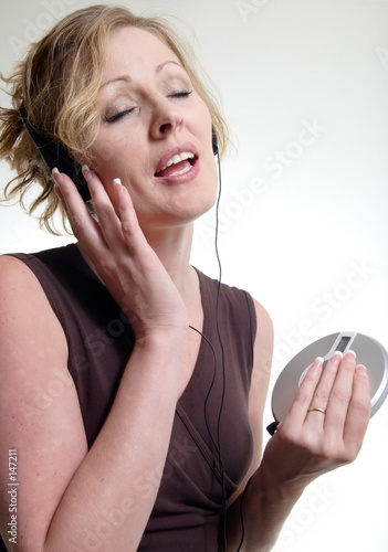 blonde woman singing while listening to cd player