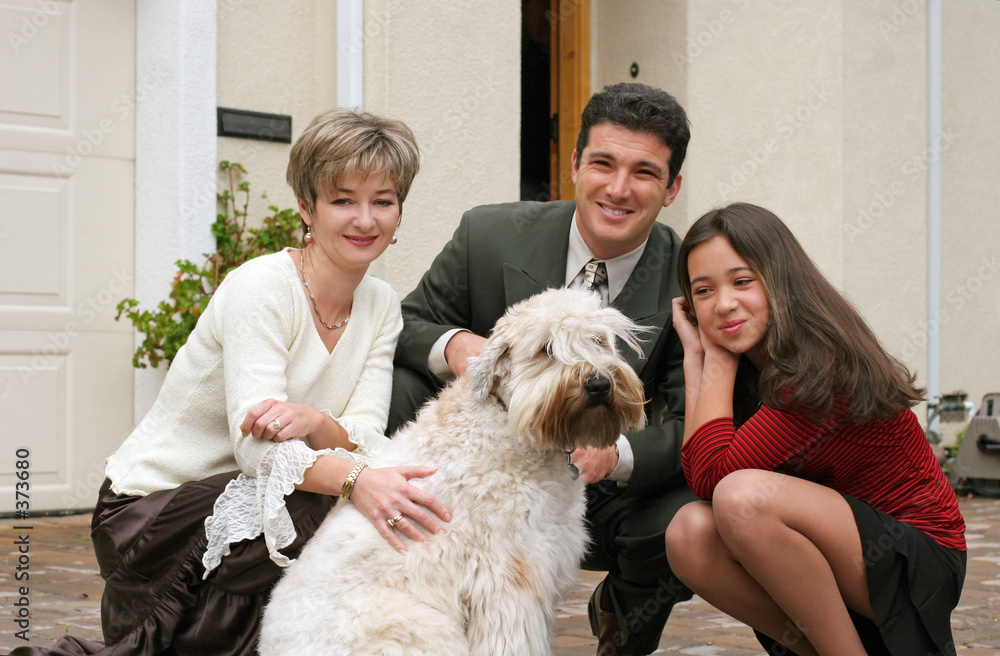 happy family with a dog in front of the home happy family with a dog in front of the home