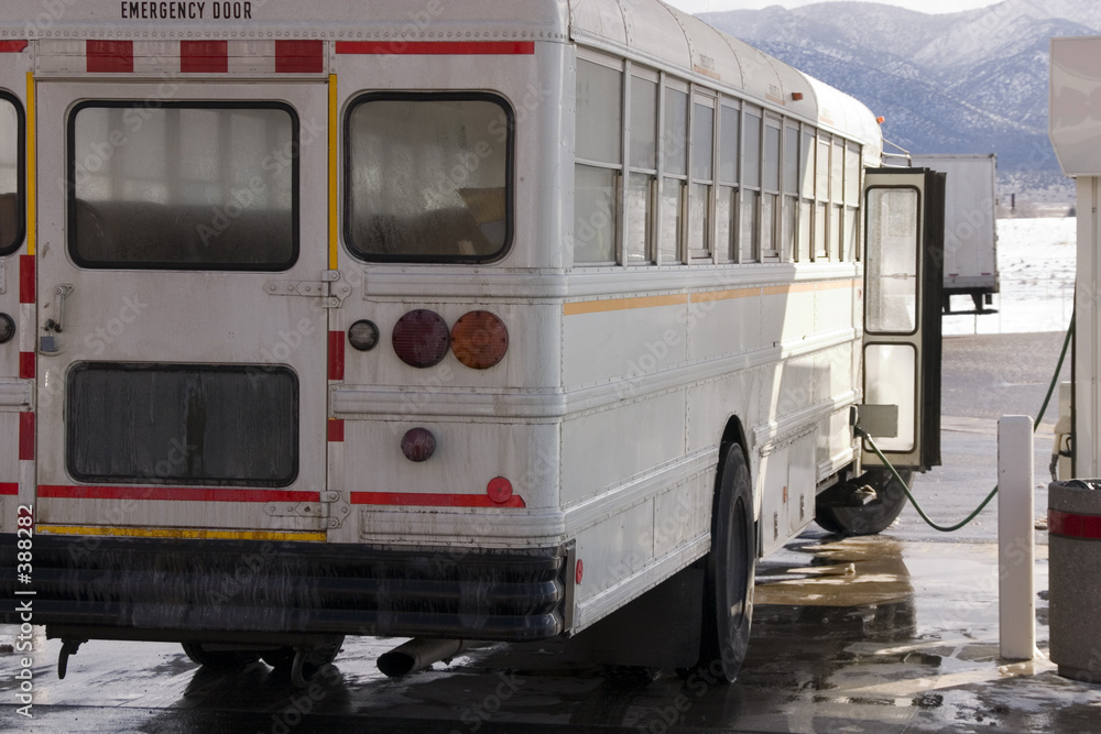 white school bus pumping gas