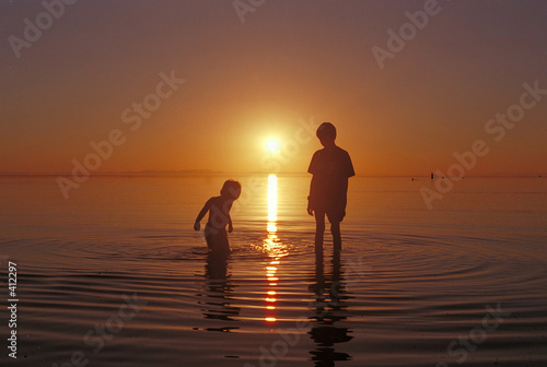 brothers playing in the water at the great salt lake beach at an