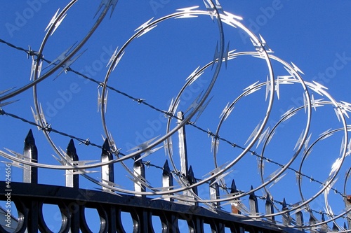 barbed and razor wire on top of fence