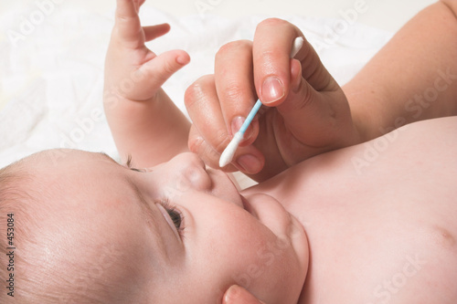 baby noze care with cotton swab © fred goldstein