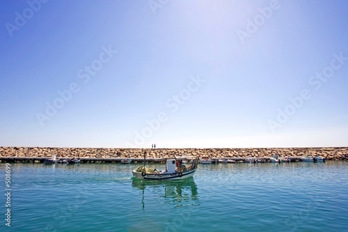 small fishing boat leaving the port of duquesa in spain