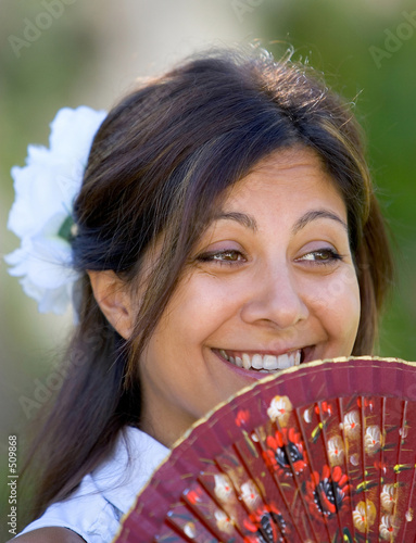 young spanish girl or woman smiling at camera holding traditiona