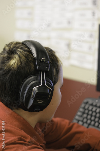 student at computer with headphones