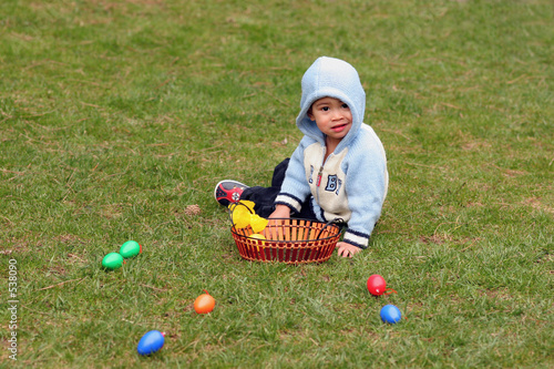 kleiner junger mit ostereiern auf der wiese photo