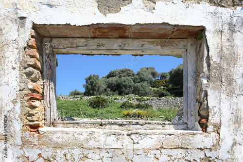 spanish countryside seen through hole in wall of ruins