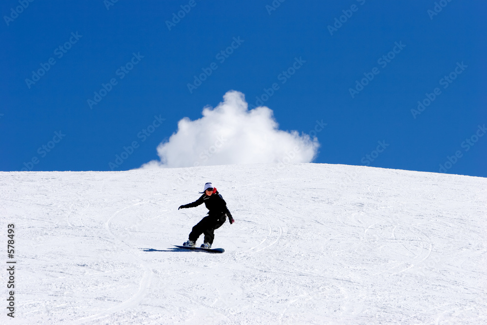 woman snowboarding on slopes of ski resort in spain