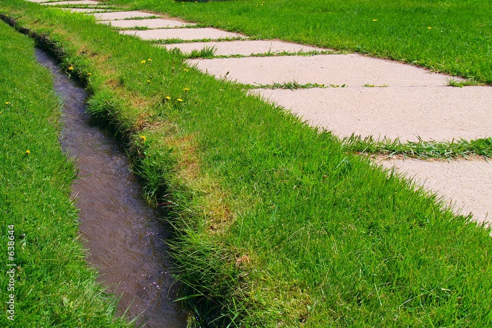 sidewalk and ditch in grass sidewalk and ditch in grass