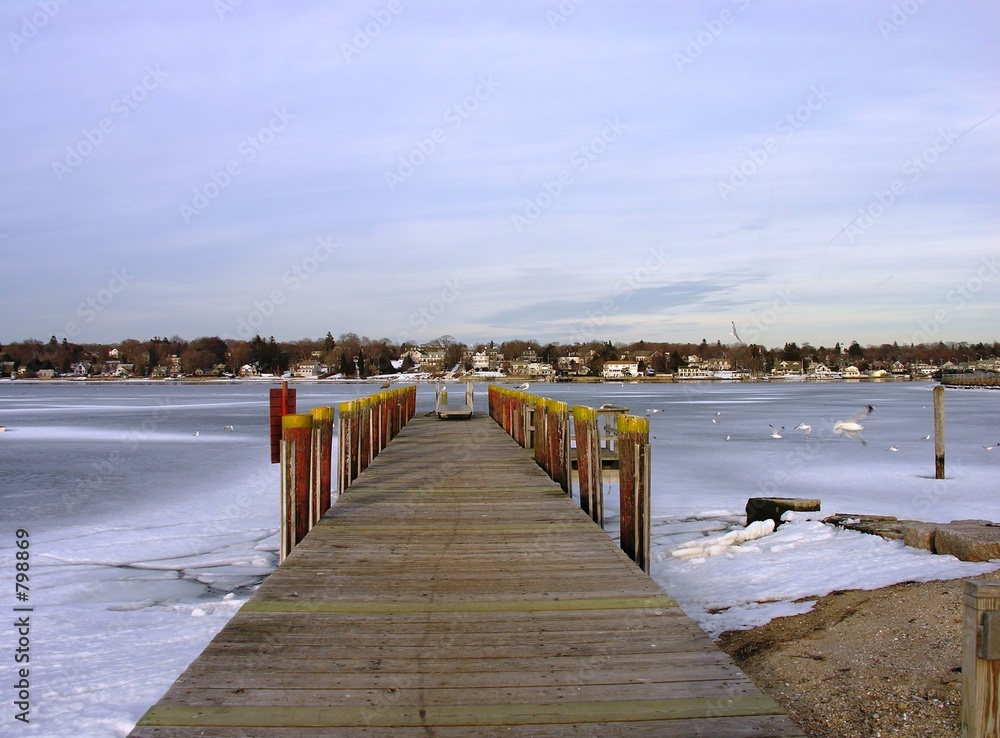 dock on a frozen bay in new england. dock on a frozen bay in new england.