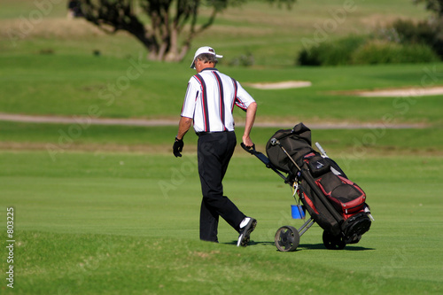 golf player walking with the golf pull cart