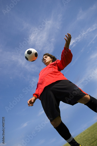 soccer football player in red controlling ball