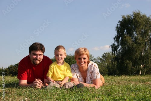 family lies on grass