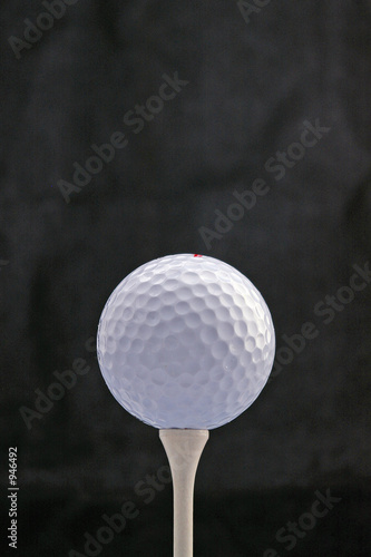 white golf ball on white tee photo