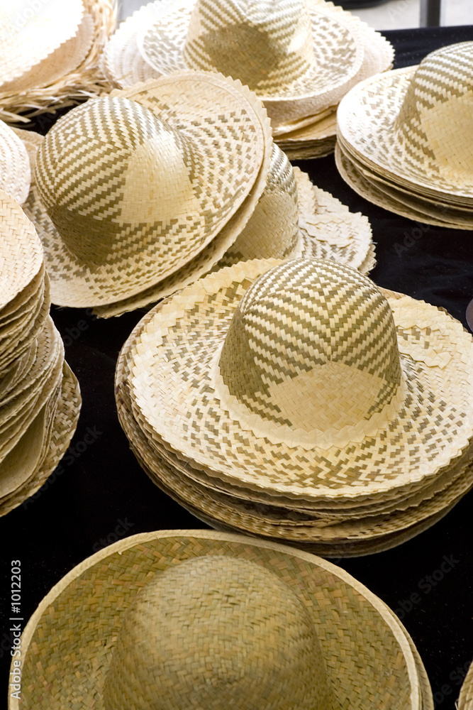 sun hats on display in a french market