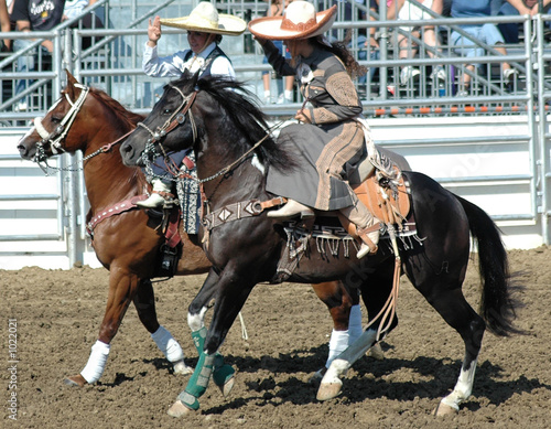 two mexican cowgirls on horseback photo