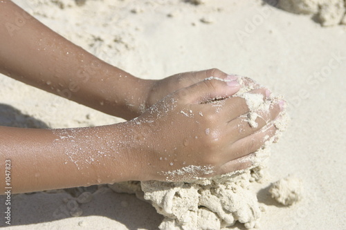 manos jugando en la arena