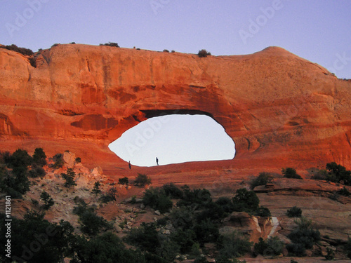 two people at wilson arch in utah