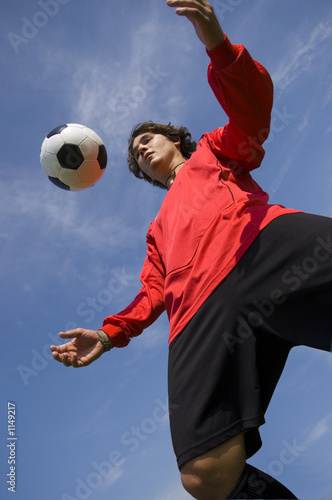 soccer football player in red controlling ball