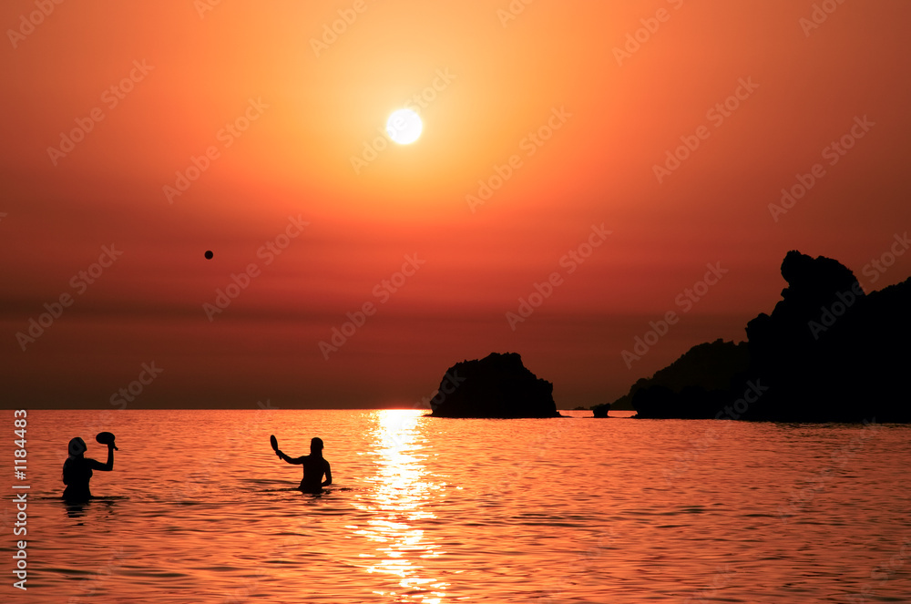 people playing tennis at sunset