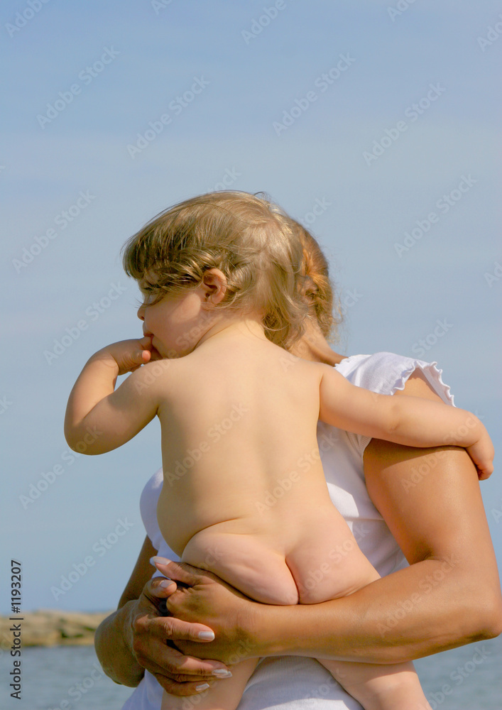 Foto de Bébé nu dans les bras do Stock
