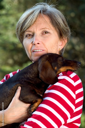Fototapeta Naklejka Na Ścianę i Meble -  woman in fifties holding a dog