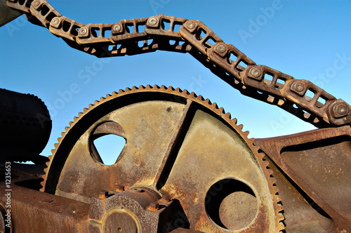 rusted industrial gear and chain with blue sky