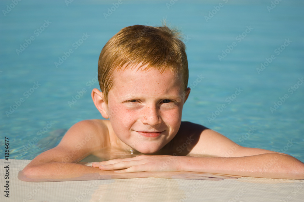 jeune garcon au bord de la piscine