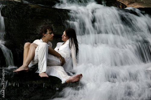 couple sitting in waterfall